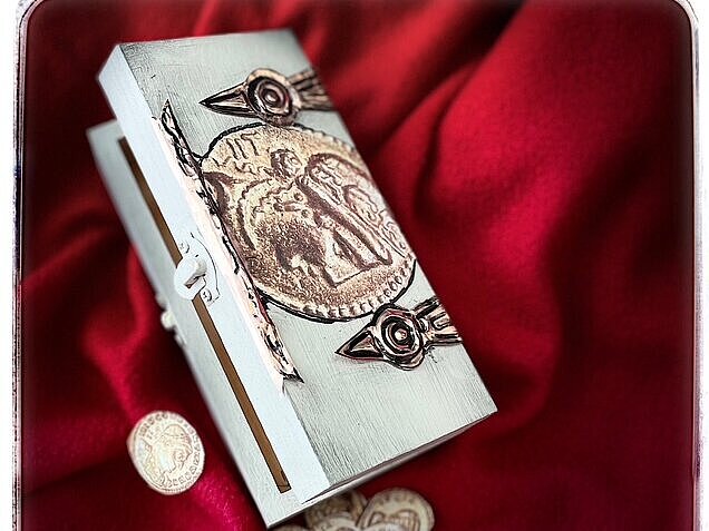 römische Schatzkiste auf ein rotes Tuch mit Geldmünzen aus Holz